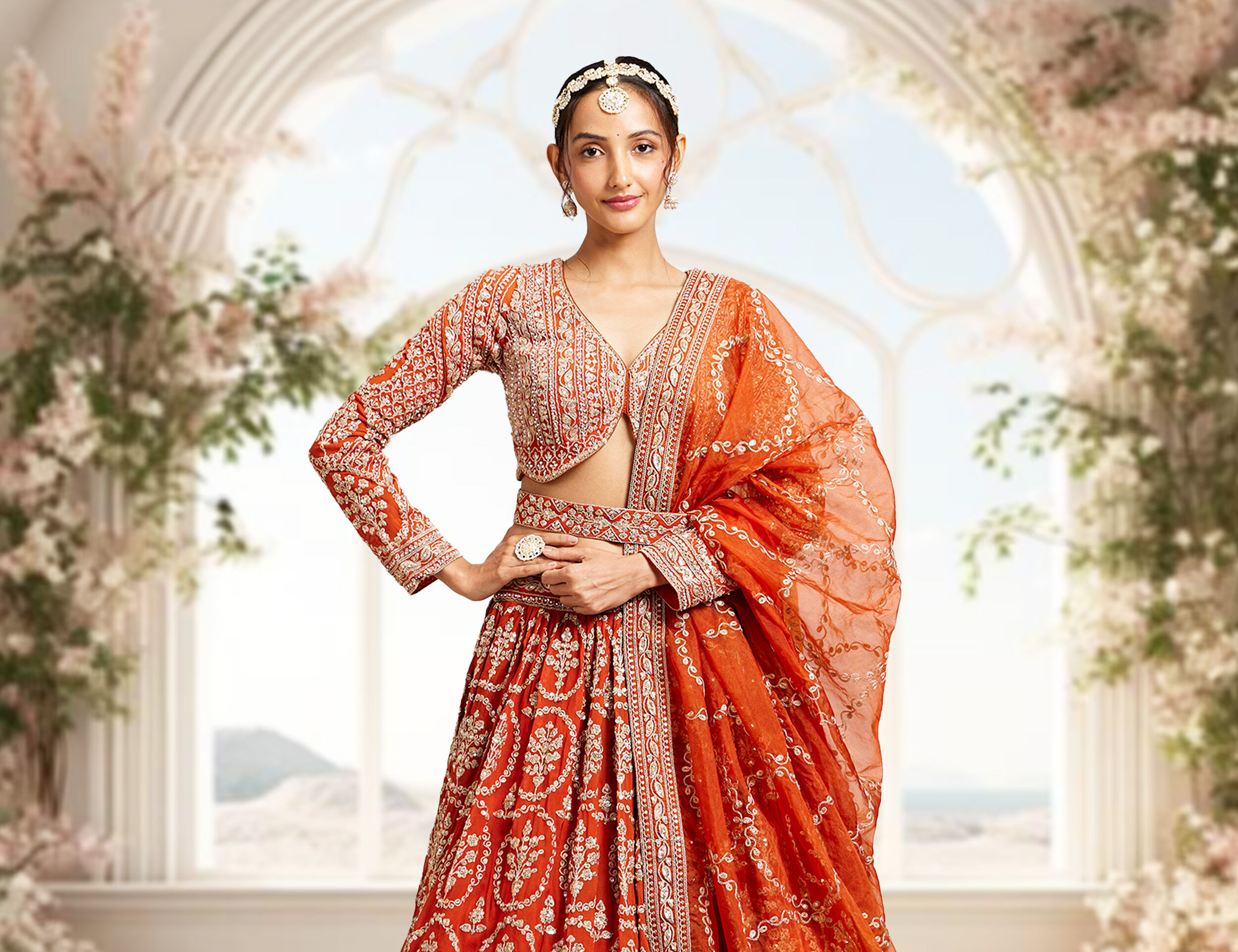Woman in a full-sleeve modern orange blouse styled with an orange lehenga.